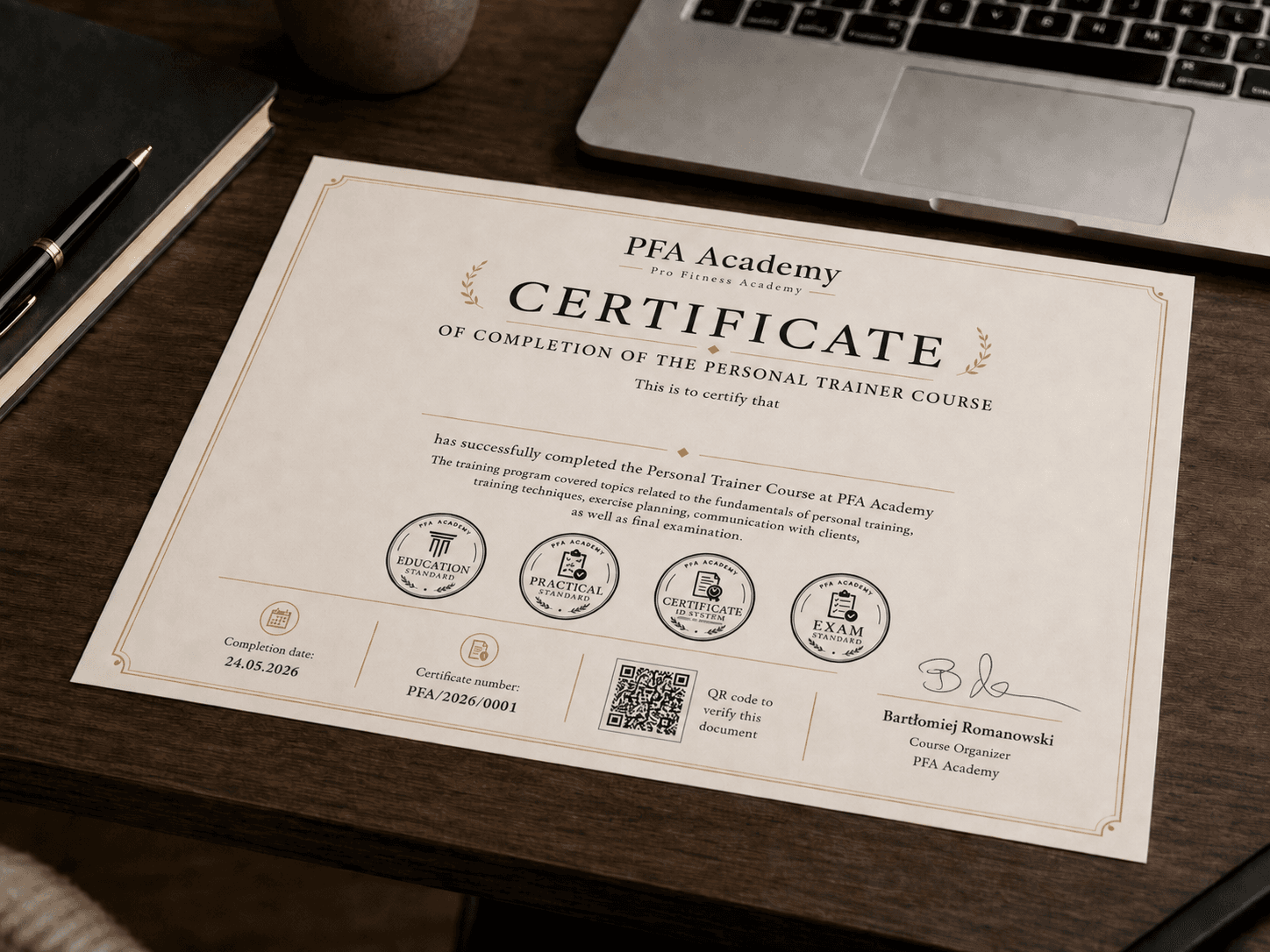 An English PFA Academy certificate lying beside a laptop